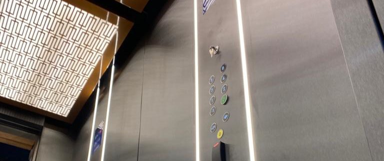 Newly installed lift with gold grab handles and ceiling lights